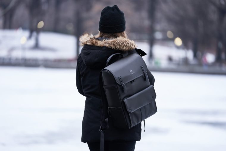 woman wearing parka and carrying backpack during winter